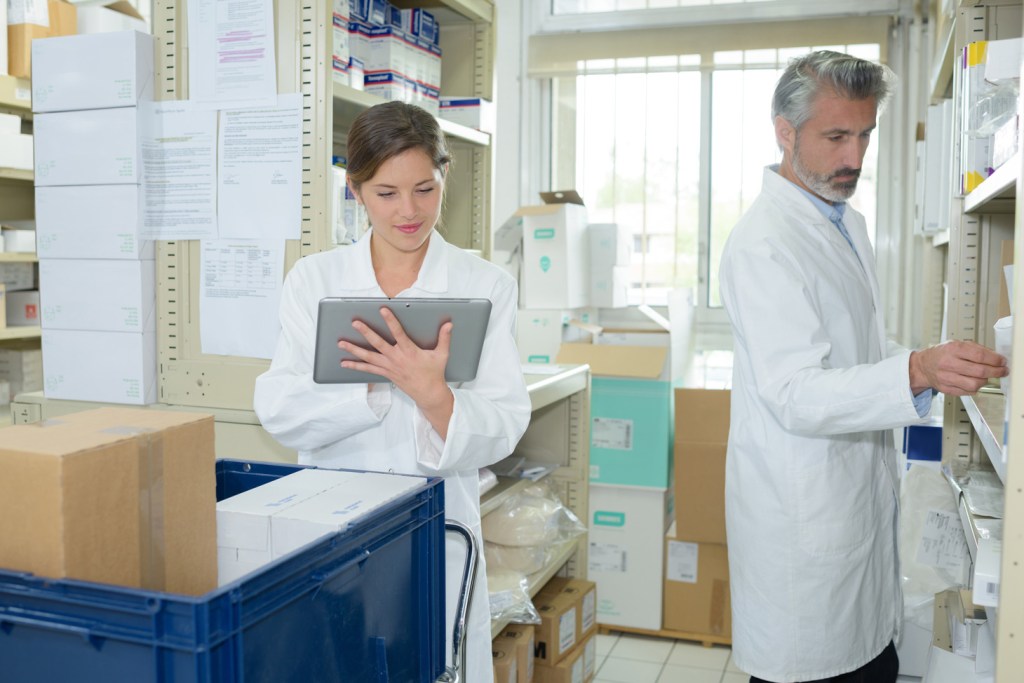Female and male doctors in a filing cabin reading.