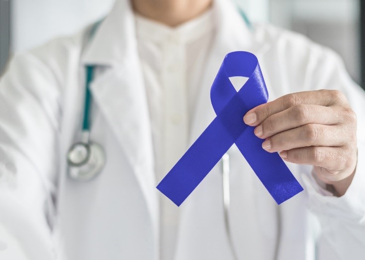 Doctor holding a blue ribbon