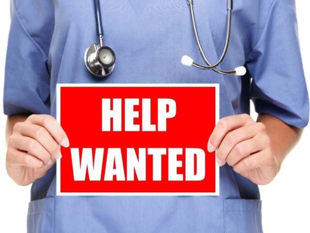 nurse holding help wanted sign
