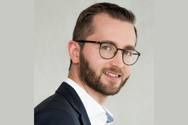 Man in a suit smiling.